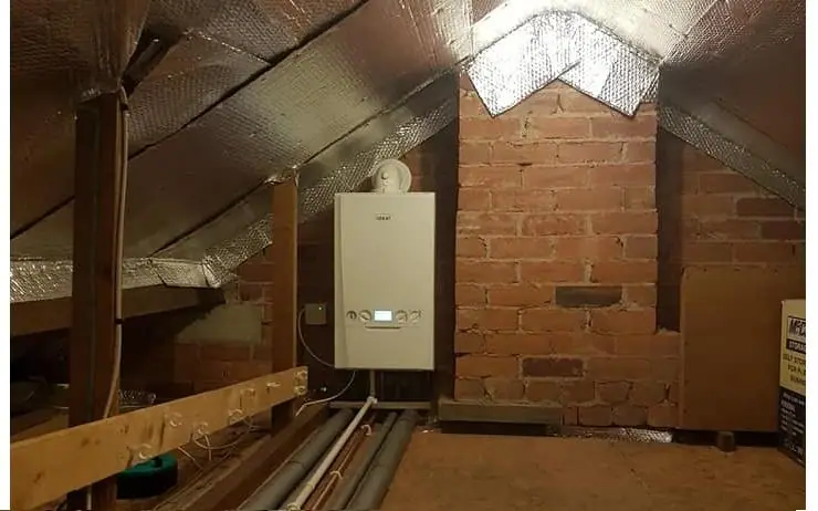 Ideal combi boiler installed in a loft space, with pipework and foil insulation